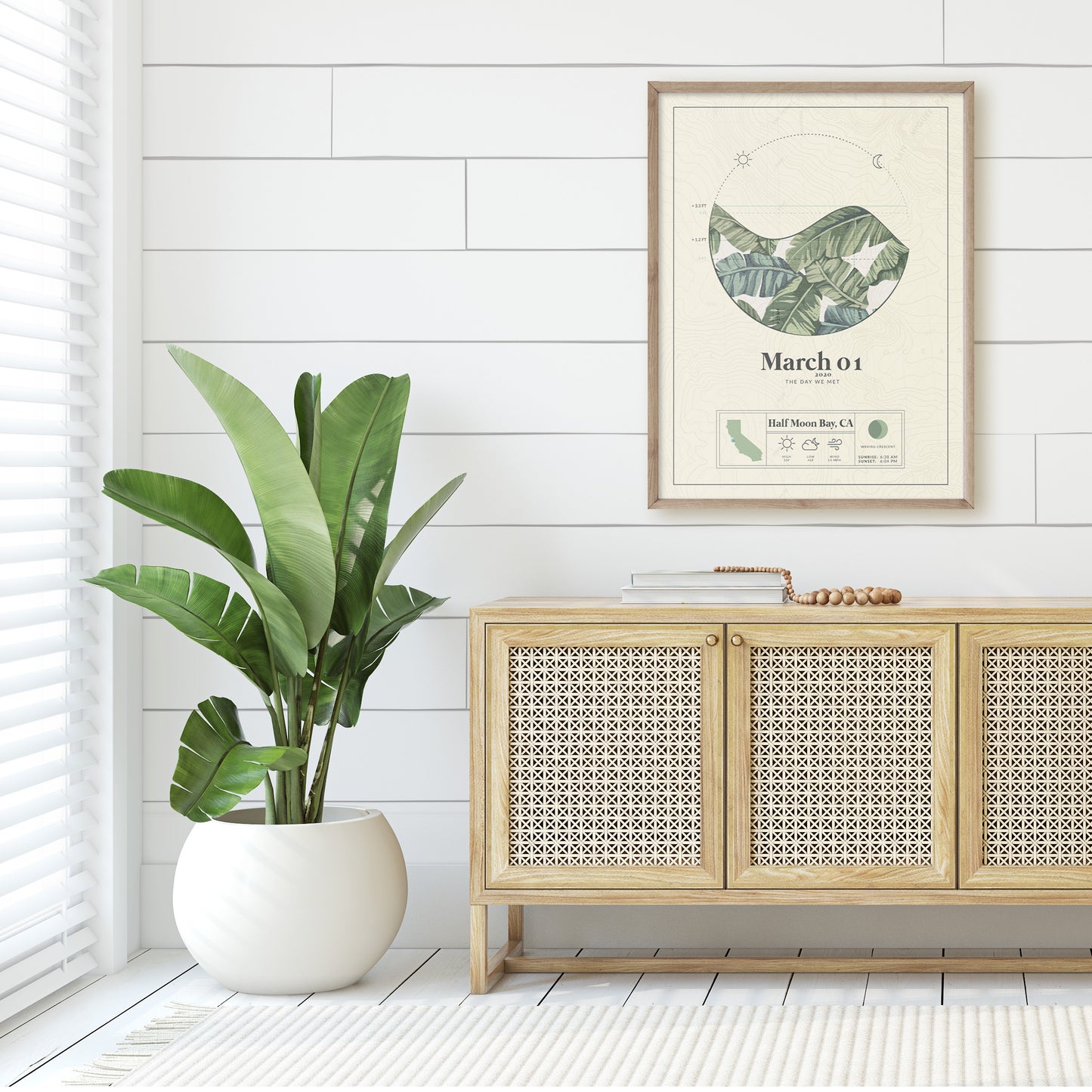 wood framed picture of the personalized tide map poster by salt atlas in the tropical island green color in a home setting. These are custom posters showing the tide, weather, and moon phase for a special day, like an anniversary or birthday.