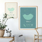 two wooden framed picture of the personalized tide poster by salt atlas in the mint & créme and Tahiti teal colors in a home setting. These are custom posters showing the tide, weather, and moon phase for a special day, like an anniversary or birthday.